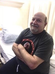 Man folding arms in black tee shirt.