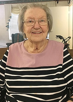 Woman smiling in pink and black shirt