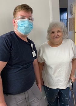 Woman in white tee shirt next to caregiver