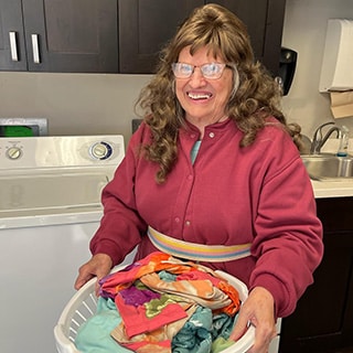 Woman in pink holding laundry basket