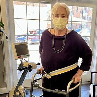 Woman with walker wearing mask.