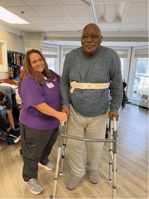 Thomas standing and using a walker