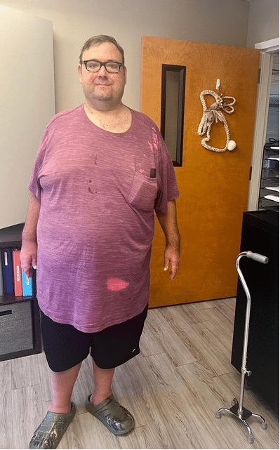 David standing in a purple shirt